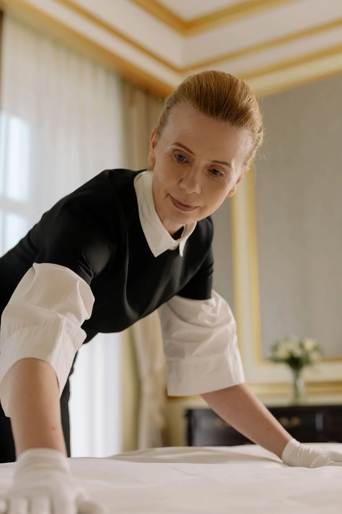 Housekeeper reder seng på et hotelværelse
